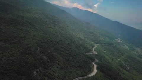 Winding road through lush mountain forest landscape Stock Footage 329510949
