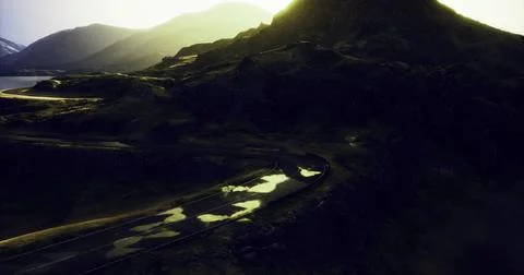 Winding road through mountainous landscape at sunset creating serene beauty Stock Illustration