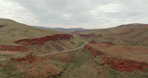 Winding Road Through Red Rock Canyons in a Desert Landscape at Dusk Vidéo 276450437