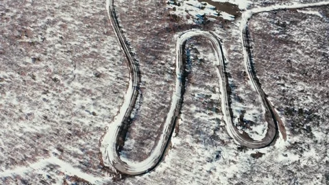 Winding road through snowy mountain forest aerial view Stock Footage 328348018
