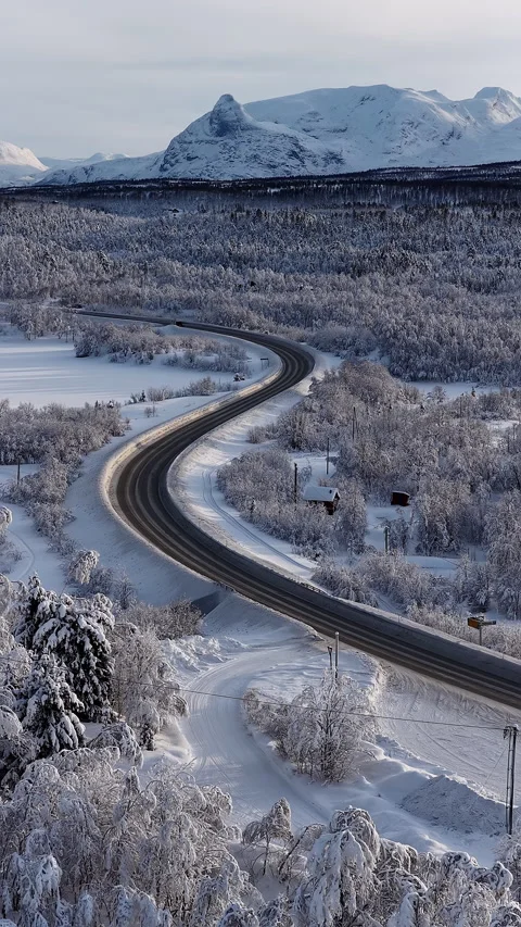 Winding road through a snowy winter landscape, Norway 스톡 동영상 345969233