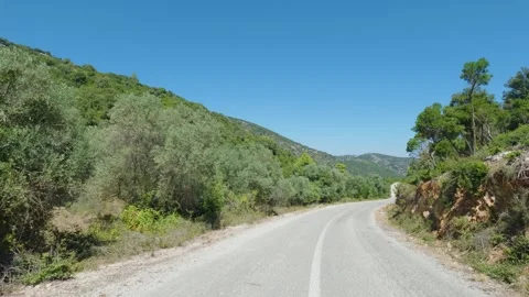 A winding rural road runs through lush green olive groves and Mediterranean Stock Footage 346712825