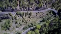 Winding serpentine road and traffic aerial top view in mountain woodland area 4k or 4k+ Resolution