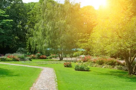 Winding Stone Path Through a Sunny Lush Garden Park Stock Photos