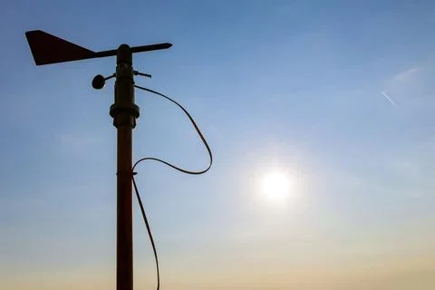 A windmill and a broken anemometer on a sunset background. Stock Photos