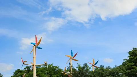 Windmill around trees with blue sky background Stock Photos