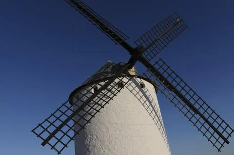 A windmill with a black frame is standing in a field Stock Photos