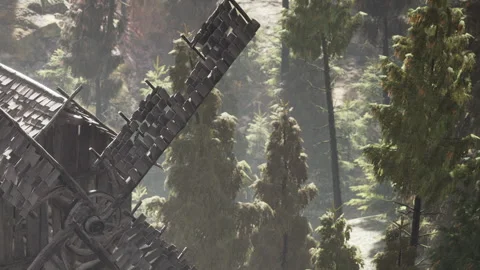 Windmill blades turn slowly in a forest during the daytime Stock Footage 345053801