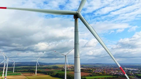 Windmill close-up against a cloudy sky. Wind turbines in a field against a Stock Footage 319843417