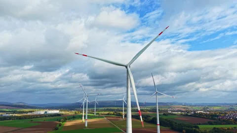 Windmill close-up against a cloudy sky. Wind turbines in a field against a Stock Footage 319843490