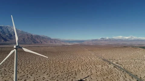 Windmill in the Coachella Valley Snow Capped Mountains Drone Flight Stock Footage 147163902