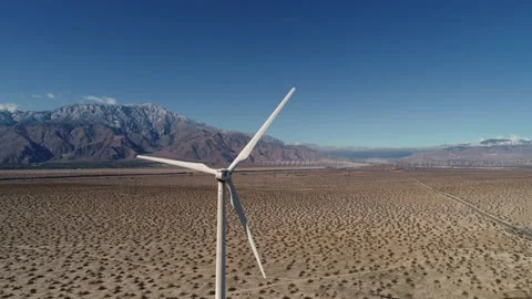 Windmill in the Coachella Valley Snow Capped Mountains Drone Flight Stock Footage 147163933