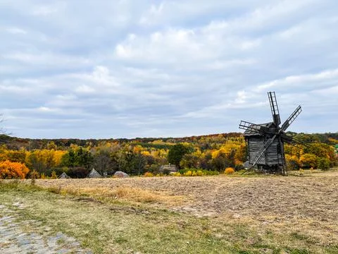Windmill on the edge of autumn field. Stock Photos