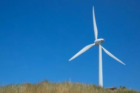 Windmill for electricity generation the background of a blue sky. Stock Photos