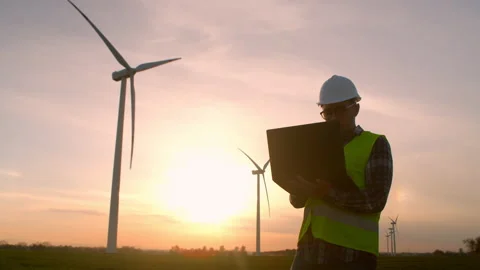 Windmill engineer. engineer at a wind farm with a tablet in his hand at sunset. Stock Footage 194421871