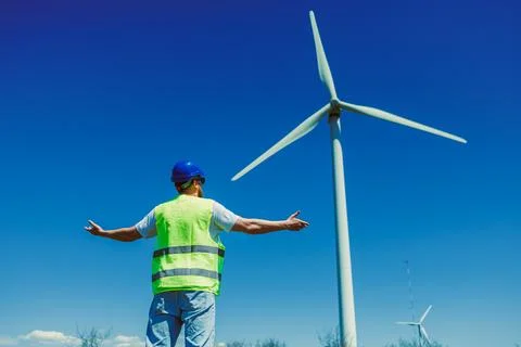 Windmill engineer inspects wind turbine at a renewable energy site on a cle.. 스톡 사진