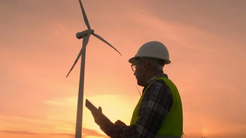 Windmill engineer watching wind turbines in operation on a tablet Video stock 197014811