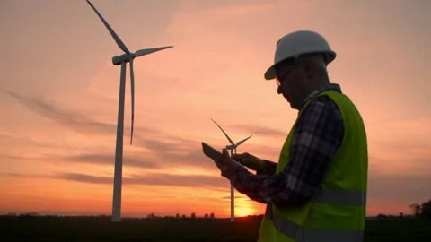 Windmill engineer watching wind turbines in operation on a tablet Stock Footage 201152296