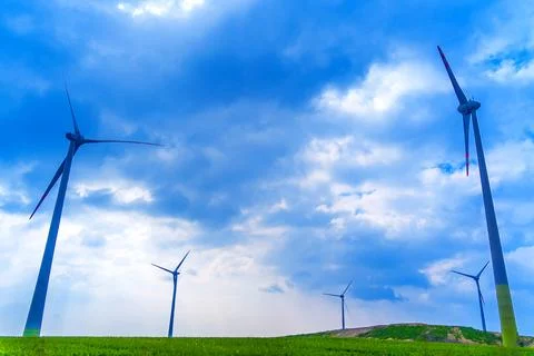 Windmill farm at the fields with beautiful blue sky Stock Photos