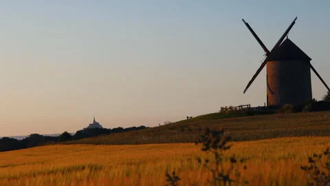 Windmill in the Foreground and High Castle in the Distance at Golden Hour Video stock 280366839