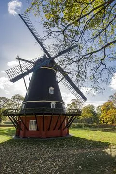 The windmill, framed by tree branches. Stock Photos