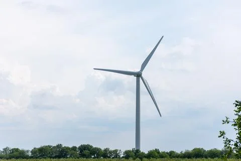 A windmill generates electricity for a locality Stock Photos