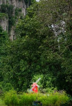 Windmill house, bright red back in the green forest. Stock Photos