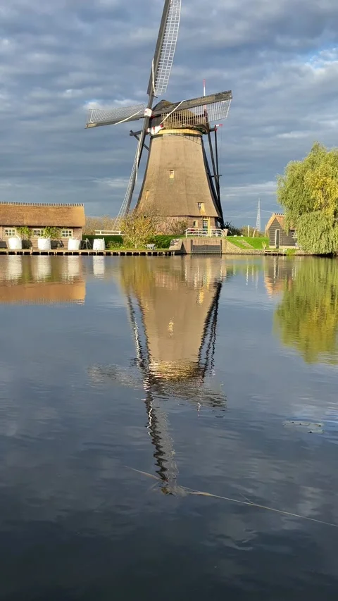 	a windmill with its reflection in the water at kinderdijk Vídeos de archivo 295361502