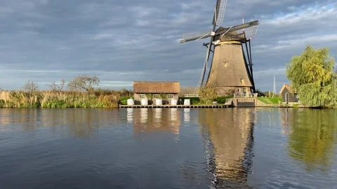 	a windmill with its reflection in the water at kinderdijk Stockbeeldmateriaal 295361503