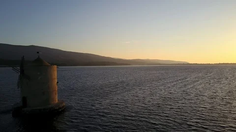 Windmill in a lagoon at sunset Stock Footage 122850329