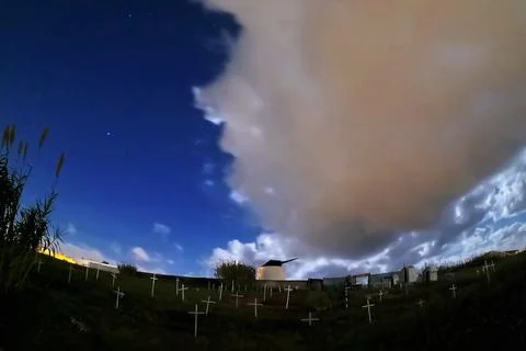 Windmill at night with dark clouds Foto stock