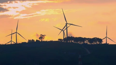 Windmill or wind turbine on sunset mountain golden sky and cloud, A wind turbine Stock Footage 95135375