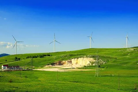 Windmill power generation on top of the mountains on the green lawn Stock Photos