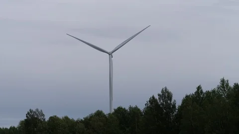 The windmill rises above the forest, generating energy. 4K Slow Mo Stock-Footage 114890935