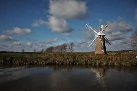 Windmill on riverbank with sky Foto stock