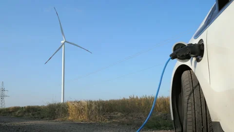 Windmill rotates behind electric ev car charging near field 库存影片 166276946