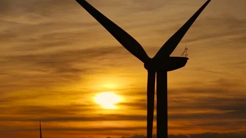 Windmill rotating with sunset backdrop. Turbine spinning while collecting Stock Footage 333777507