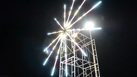 Windmill runs in the night, illuminated by the lights. Hand-held phone defocus Stock Footage 124988200