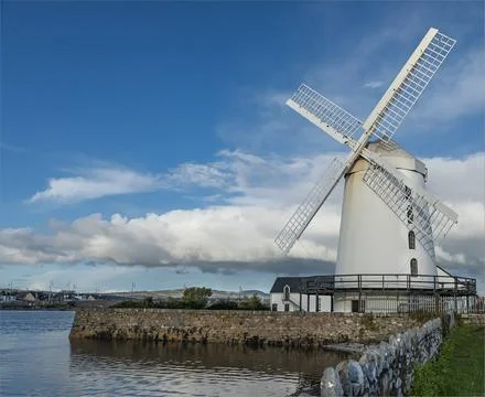 Windmill by the side of a river painted white Stock Photos