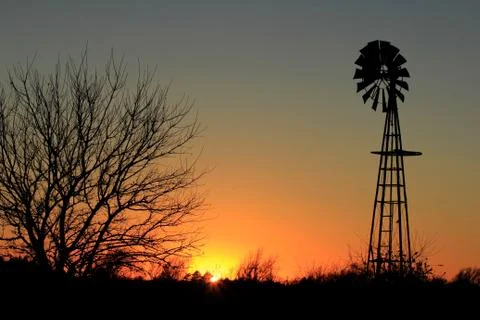 Windmill Silhouette Sunset with trees 库存照片