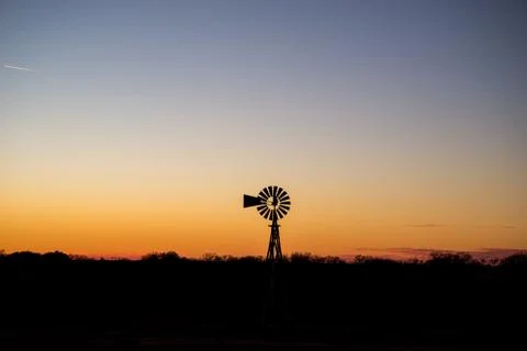 Windmill silhouetted in the Texas sunset Stock Photos