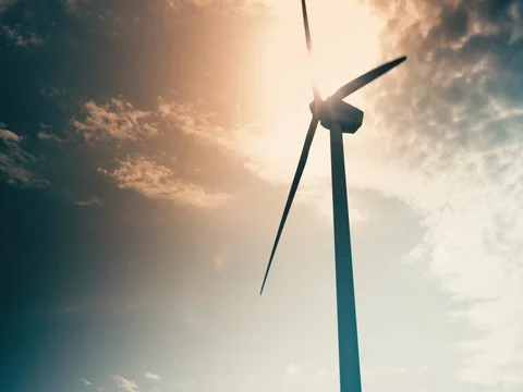 Windmill slowly spinning against dramatic orange blue sky with clouds Stock Footage 72948397