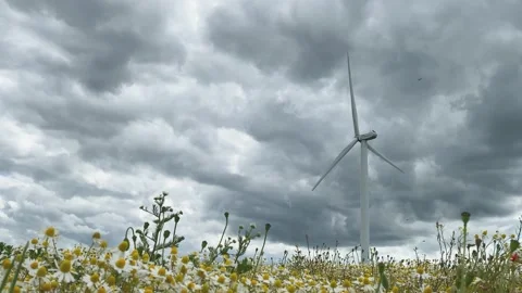 The windmill is spinning slowly, producing environmentally friendly, green en Stock Footage 133173377