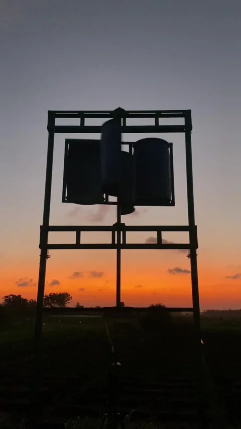 A windmill spins at sunset Stock Footage 295011832