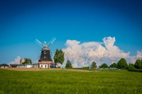 Windmill in spring behind a grain field Stock Photos