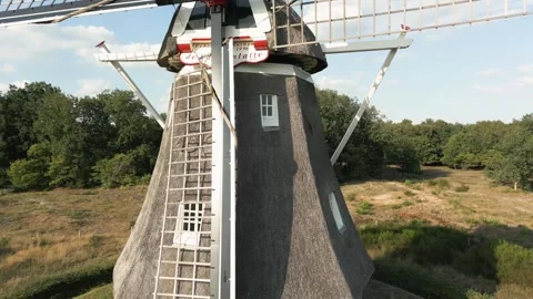 Windmill standing strong amidst lush green forest Видео 293158372