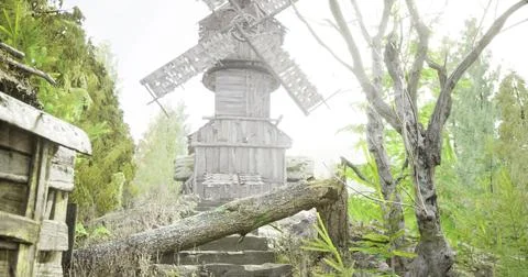 Windmill stands tall amidst dense fog in a forest Ilustração Stock