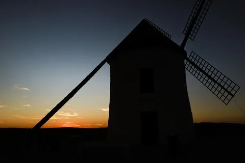 Windmill at sunset in Cerro de San Juan hill in Pozo Canada town, Castilla .. Stock Photos