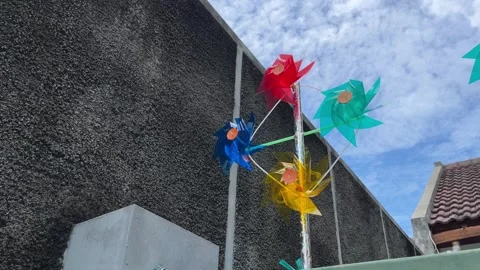 Windmill toys spinning in the wind under the sky Stock Footage 274040818