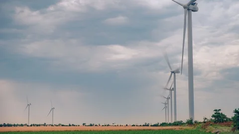 Windmill turbine generating clean renewable energy in green agricultural field. Stock Footage 111919701